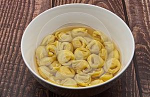 Traditional Italian Tortellini in brodo on wooden table photo