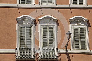 Traditional Italian windows and balconies with shutters in one o