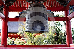 Traditional Japanese bell in a temple inscribed with Japanese wishes for prayers