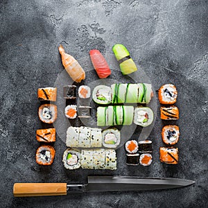 Traditional Japanese food of sushi, rolls and knife on grey background. Flat lay, Top view