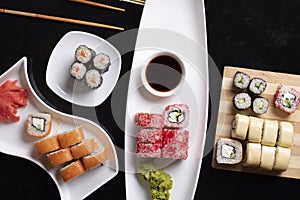 Traditional Japanese food - sushi, rolls, rice with shrimp and udon noodles on a dark background. Top view