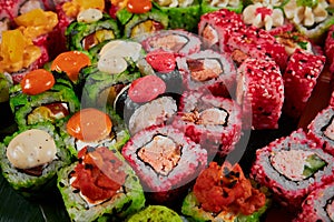 Traditional Japanese food - sushi, rolls and sauce on a black background. Top view.