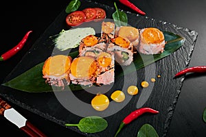 Traditional Japanese food - sushi, rolls and sauce on a black background. Top view.