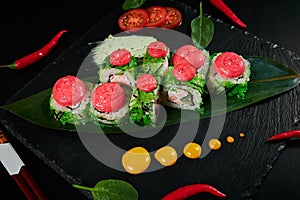 Traditional Japanese food - sushi, rolls and sauce on a black background. Top view.