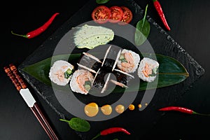 Traditional Japanese food - sushi, rolls and sauce on a black background. Top view.