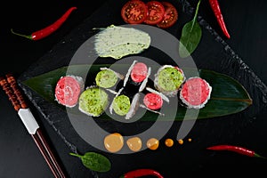 Traditional Japanese food - sushi, rolls and sauce on a black background. Top view.