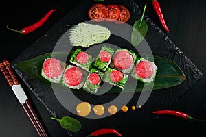 Traditional Japanese food - sushi, rolls and sauce on a black background. Top view.