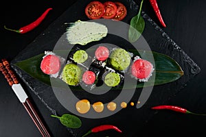 Traditional Japanese food - sushi, rolls and sauce on a black background. Top view.