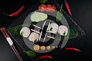 Traditional Japanese food - sushi, rolls and sauce on a black background. Top view.