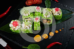 Traditional Japanese food - sushi, rolls and sauce on a black background. Top view.