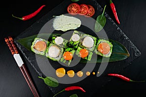 Traditional Japanese food - sushi, rolls and sauce on a black background. Top view.