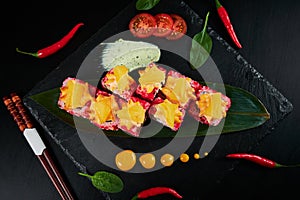 Traditional Japanese food - sushi, rolls and sauce on a black background. Top view.