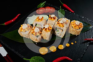 Traditional Japanese food - sushi, rolls and sauce on a black background. Top view.