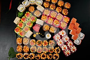 Traditional Japanese food - sushi, rolls and sauce on a black background. Top view.