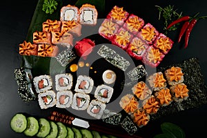 Traditional Japanese food - sushi, rolls and sauce on a black background. Top view.