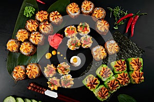 Traditional Japanese food - sushi, rolls and sauce on a black background. Top view.