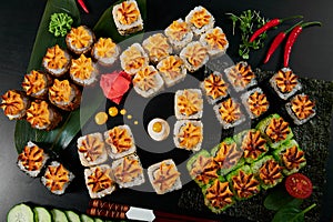 Traditional Japanese food - sushi, rolls and sauce on a black background. Top view.