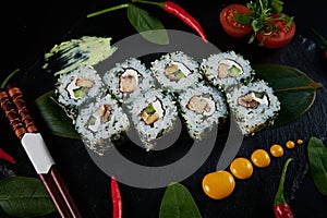 Traditional Japanese food - sushi, rolls and sauce on a black background. Top view.