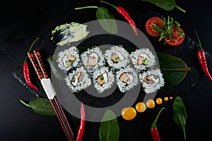 Traditional Japanese food - sushi, rolls and sauce on a black background. Top view.