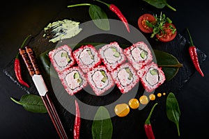 Traditional Japanese food - sushi, rolls and sauce on a black background. Top view.