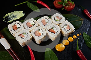 Traditional Japanese food - sushi, rolls and sauce on a black background. Top view.