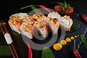 Traditional Japanese food - sushi, rolls and sauce on a black background. Top view.