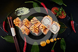 Traditional Japanese food - sushi, rolls and sauce on a black background. Top view.