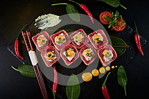 Traditional Japanese food - sushi, rolls and sauce on a black background. Top view.