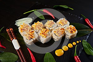 Traditional Japanese food - sushi, rolls and sauce on a black background. Top view.