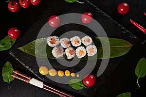 Traditional Japanese food - sushi, rolls and sauce on a black background. Top view.