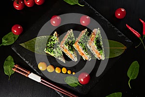 Traditional Japanese food - sushi, rolls and sauce on a black background. Top view.