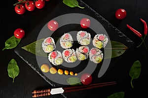 Traditional Japanese food - sushi, rolls and sauce on a black background. Top view.