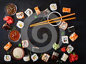 Traditional Japanese food - sushi, rolls and sauce on a dark background.
