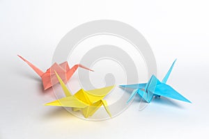 Traditional Japanese origami cranes made of paper on a white background. Multicolored paper birds.