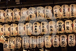 Traditional Japanese paper lantern with Japanese Characters in a raw in Yasaka Shrine, Kyoto, Japan