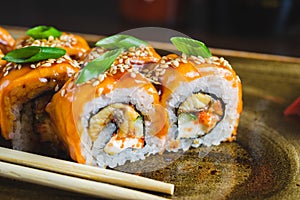 Traditional Japanese rolls with salmon fish, eel, seafood on a plate with wooden chopsticks