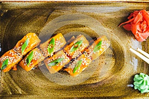 Traditional Japanese rolls with salmon fish, eel, seafood on a plate with wooden chopsticks