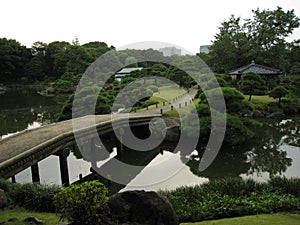 Traditional Japanese stroll garden with bridge across pond