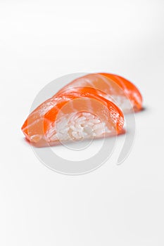 Traditional japanese sushi nigiri with salmon on a white background, vertical shot