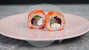 Traditional Japanese sushi rolls stuffed with seafood and curd cheese with vegetables sprinkled with flying fish caviar
