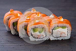 .traditional Japanese sushi with shrimp salmon soft cheese cucumber and red caviar decorated with creamy sauce. Japanese