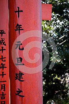 Traditional Japanese text on red Torii gate posts in Japan