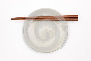 Traditional Japanese wooden chopstick on white ceramic plate