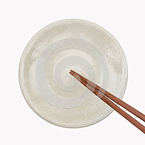 Traditional Japanese wooden chopstick on white ceramic plate