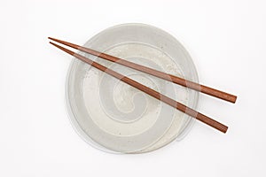 Traditional Japanese wooden chopstick on white ceramic plate