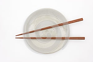 Traditional Japanese wooden chopstick on white ceramic plate