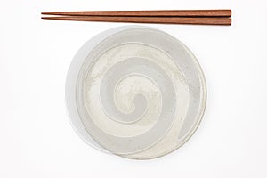 Traditional Japanese wooden chopstick and white ceramic plate