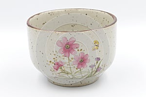 Traditional japonese tea cup with three pink flowers.