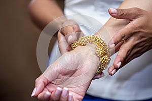 Traditional jewelry placement in a Cambodian wedding ceremony