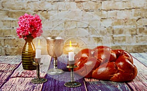 Traditional Jewish Sabbath Shalom ritual fresh challah bread on kiddush cup of red kosher wine